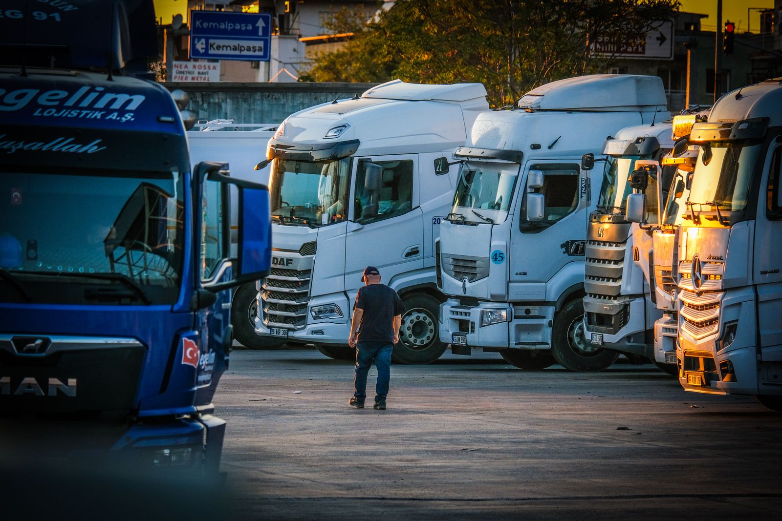 Lorry driver walking towards parked trucks at a depot