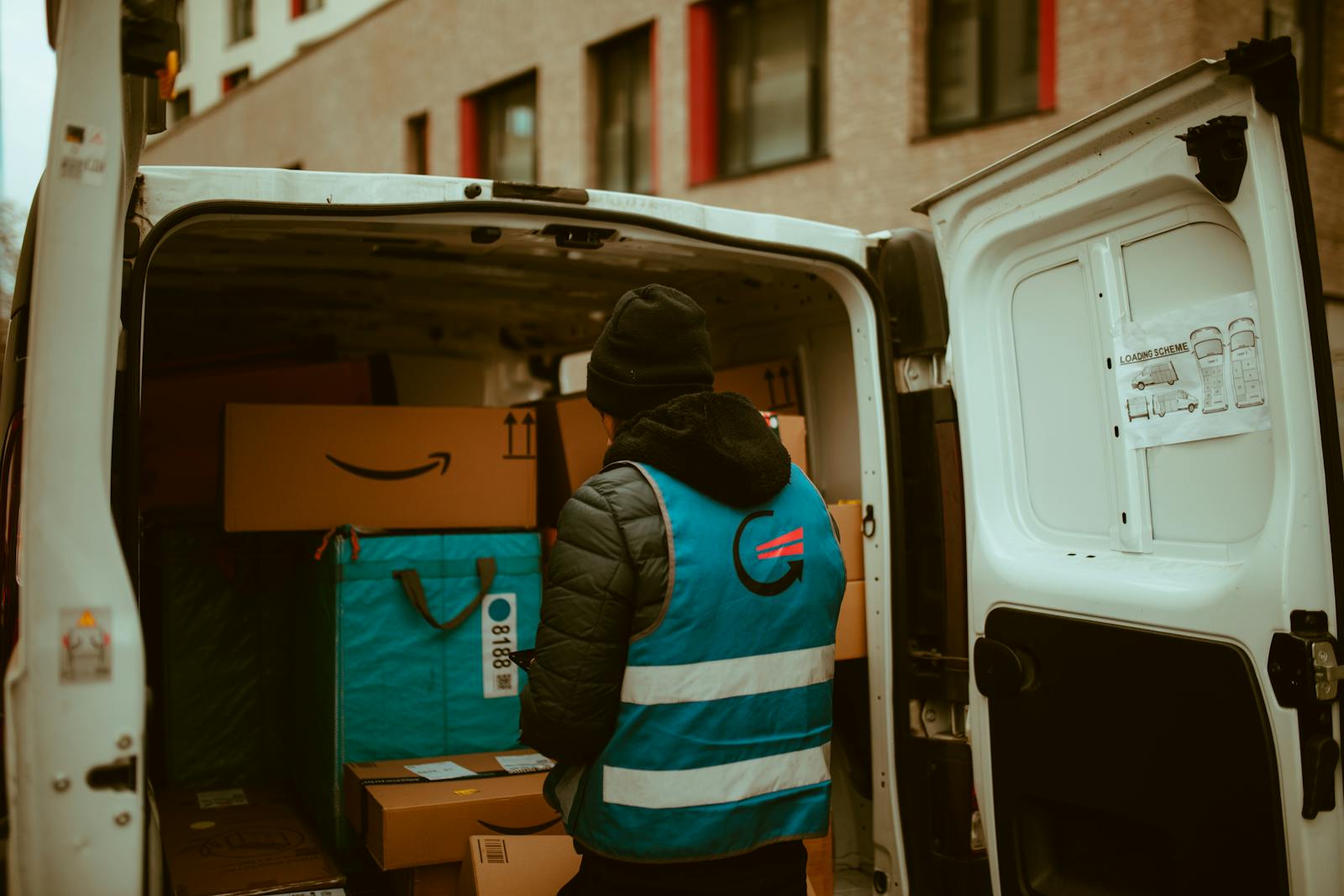 Delivery driver loading parcels into a van