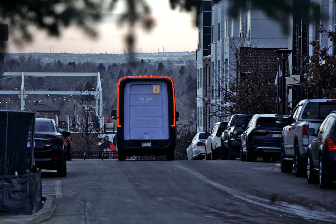 Amazon delivery van on a street at dusk