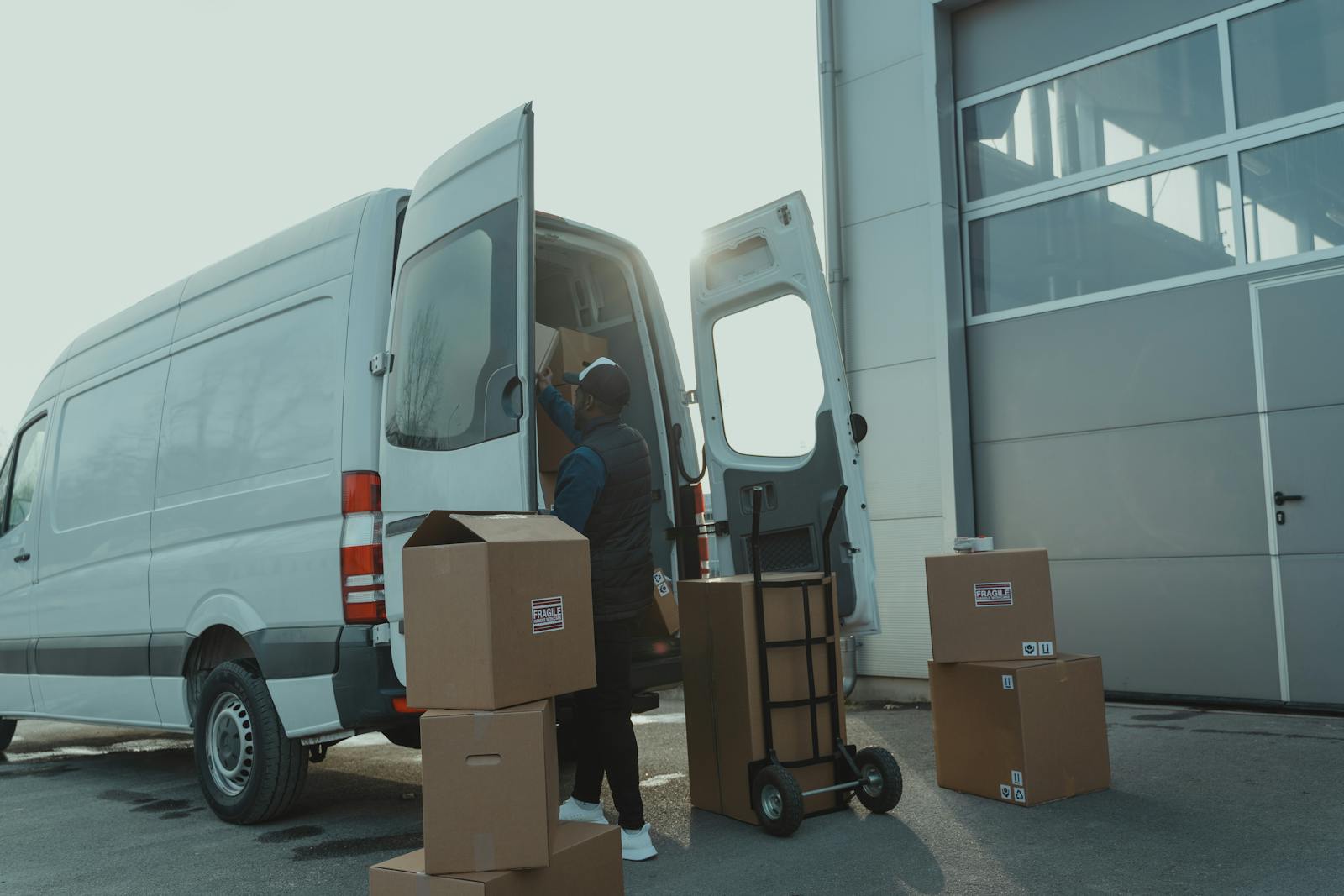 Driver loading parcels into a delivery van at a depot